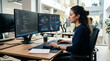 © imagemir - A young Hispanic woman focused on coding at her dual-monitor workstation in a modern office environment.