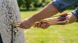 © Stitch - Archer pulling a cluster of wooden arrows with bright colored fletching out of a thick black foam archery target