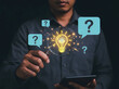 © Uttara Graphic - Person holding a magnifying glass over a glowing light bulb surrounded by question marks symbolizing creativity and problemsolving