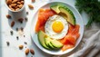 © Viktor - Balanced breakfast plate with fried egg salmon avocado and almonds. Healthy meal offers protein healthy fats and vitamins. Morning food presented on white plate with natural light.