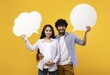 © Prostock-studio - Smiling Indian Couple Expecting A Baby, Holding Blank Speech Bubbles In Front Of Yellow Background. Joyful Emotion Captured In Studio Setting, Celebrating Parenthood Journey Together, Concept.
