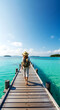 © DesignByNoor - Woman walking on a wooden pier over blue tropical ocean