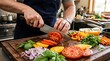 © Ahmad - Professional chef slicing fresh heirloom tomato on wooden cutting board