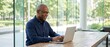 © ThamDesign - Older African latin note executive corporate investment old laptop senior ceo business mature businessman man age manage tech manager technology finance office adult male investor banker job company