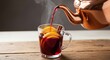 © Hugnaka - Warm spiced mulled wine flows from a polished copper kettle into a glass mug with orange slices and cinnamon on a rustic wooden board, fruit, cozy, culinary