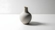 © Huzaifa Creatives - A smooth minimalist ceramic vase features a round body with a narrow neck sitting in soft natural indoor studio lighting