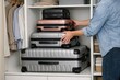 © Fotograf - A person storing travel bags and cases in a small room