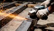 © Netsai - A close-up view of a metal worker using a handheld power grinder to smooth a steel frame piece.