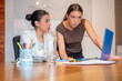 © Nicolas Ospina - Two Female Colleagues Collaborating Over Laptop During Business Meeting With Whiteboard Chart And Copy Space.