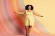 © miss irine - Joyful plus size woman dances with open arms on colorful background. She wears a yellow striped dress, smiling broadly expressing pure happiness and freedom. Her confident body moves energetically.
