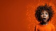 © svastix - An amazed young boy with curly hair stares with wide eyes against a bright orange backdrop, capturing the essence of wonder and curiosity in a playful yet artistic way.