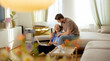 © BGStock72 - Couple shares joyful moments at home while working on a laptop in the living room