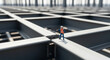 © Kartono - A tiny construction worker figurine stands on a vast grid of steel beams, symbolizing scale and the early stages of building development.