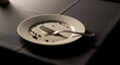 © Tufayel - A close-up view of a shiny, empty plate with a fork resting on it.