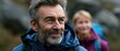 © gunzexx png and bg - A mature man with a thoughtful expression hiking in a scenic outdoor setting, embodying adventure, determination, and the spirit of exploration in a tranquil natural environment.
