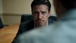 © Rayn - A worried, sweating man in a suit looking anxious during an intense corporate investigation meeting or legal interrogation session, reflecting fear, guilt, and high pressure.