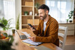 © Miljan Živković - Man scanning documents with smart phone working from home