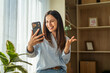 © Miljan Živković - Woman smiling and waving during video call