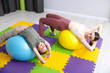 © New Africa - Little girl and trainer exercising with fitness balls indoors