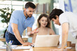 © JackF - Group of colleagues discussing around laptop at office table