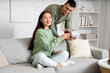 © Pixel-Shot - Happy couple with glasses of warm mulled wine on tray in living room