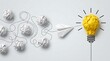 © Aish-Studio - Paper airplane navigating through crumpled paper obstacles towards a bright yellow crumpled paper lightbulb representing innovation and a new idea.