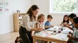 © Alva - A smiling female teacher helps a group of diverse young children paint colorful pictures at a table in a bright classroom.