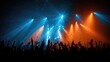 © Farid - Crowd with hands raised under dramatic blue and orange stage lights