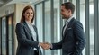 © Atta - Business Professionals Shaking Hands in Modern Office Setting with Natural Light