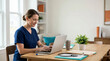 © OlgaNeuroArt - Home nurse in blue scrubs working on a laptop at a wooden table. Telehealth and medical records management. Healthcare professional at home