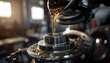 © FIFO STOCK - Industrial machinery lubrication process with golden oil pouring into a precision mechanical component in a factory setting