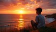 © Viktor - Teenager watches golden sunset over calm ocean waves from grassy cliff. Boy gazes at sun dipping below horizon, sky ablaze with orange and red hues. Peaceful seaside contemplation.