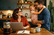 © Rohan Katwe - woman using laptop in modern kitchen, work from home lifestyle, parenting, remote work balance, happy family bonding, cozy home interior, digital living, everyday happiness daughter father with mother
