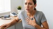 © Musarrof - Young Woman Clutching Her Chest and Experiencing Pain and Distress in a Medical Clinic, Symptoms of Heart Attack or Panic Attack