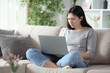© PheelingsMedia - Angry asian woman checking laptop at home