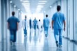© Januar - Blurred figures in bright hospital corridor, walking away