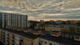 High angle view of a residential concrete block of flats with modern city skyscrapers in the background at sunset