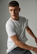 © Platon - Dynamic studio shot of a young man in a basic white tee.