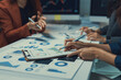 © Crystal - Business team collaborating, reviewing financial reports and marketing strategy, analyzing data graphs for business growth
