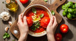 © sekar - Fresh Tomato Soup Preparation: Hands Adding Tomatoes to Bowl with Garlic and Basil
