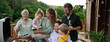 © Halfpoint - Multi generation family grilling outside on patio in summer during garden party