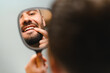 © Serhii - Man checking oral health looking in mirror