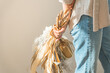© buritora - A woman holding a swag of dried flowers by a window bathed in the setting sun (model, fashion, light, shadow)
