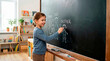 © Xenia - Smiling young girl drawing her family on a chalkboard. Elementary student writing with chalk in classroom