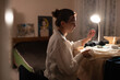 © Niyaz Tavkaev/Stocksy - Seamstress sewing at home in lamplight