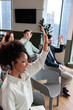 © Jovo Jovanovic/Stocksy - People raising hands in a meeting or presentation.