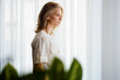 © OchreOchre/Stocksy - Woman Standing in Profile by Window With Plants