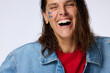 © ohlamourstudio/Stocksy - Woman Laughs Happily With Blue Decorations on Her Face
