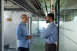 © Dimitrije Tanaskovic/Stocksy - Coworkers chat in the hallway