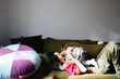 © OchreOchre/Stocksy - Mother and Child Cuddling Playfully on Green Sofa